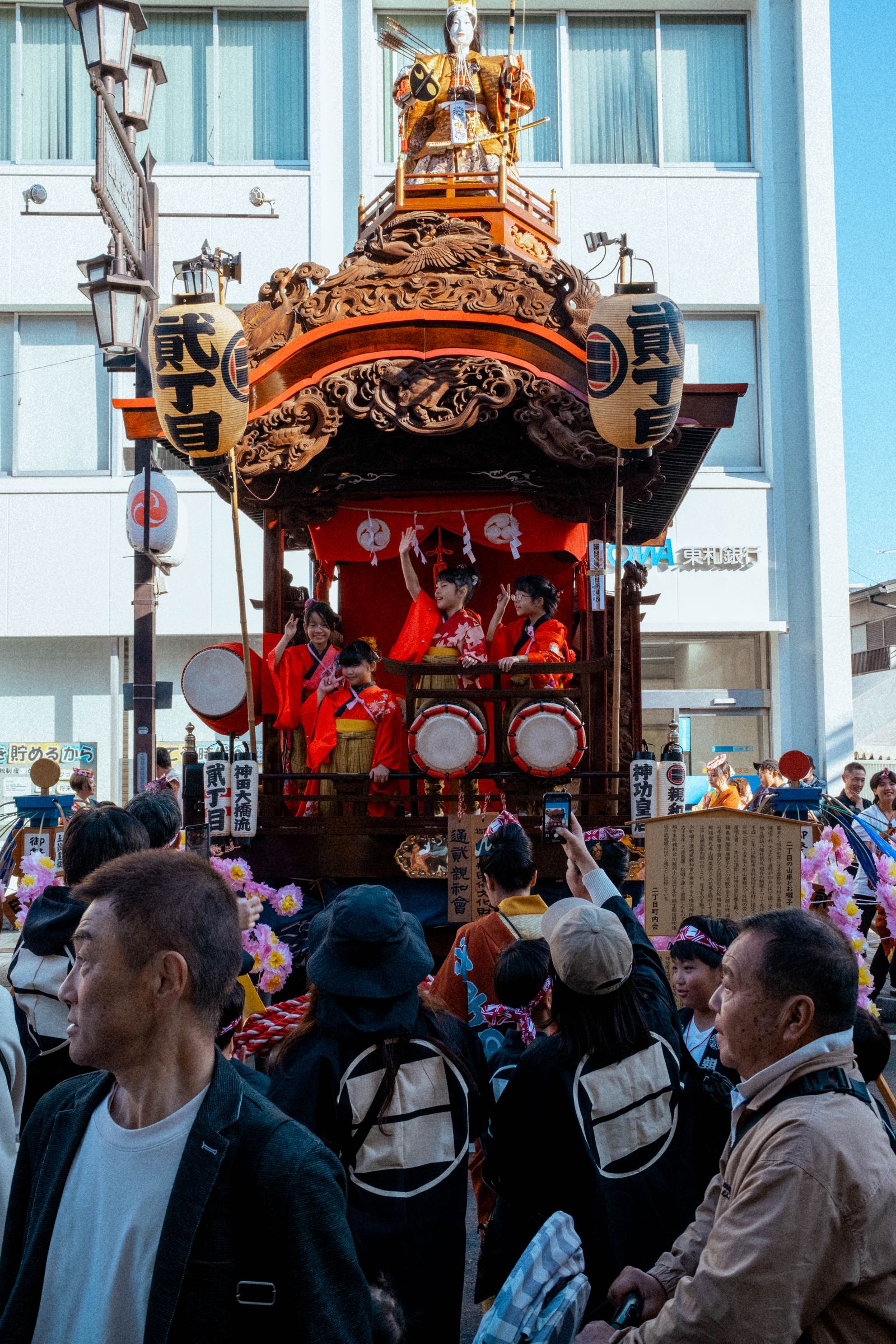 A festival float carried through a crowd in traditional costume