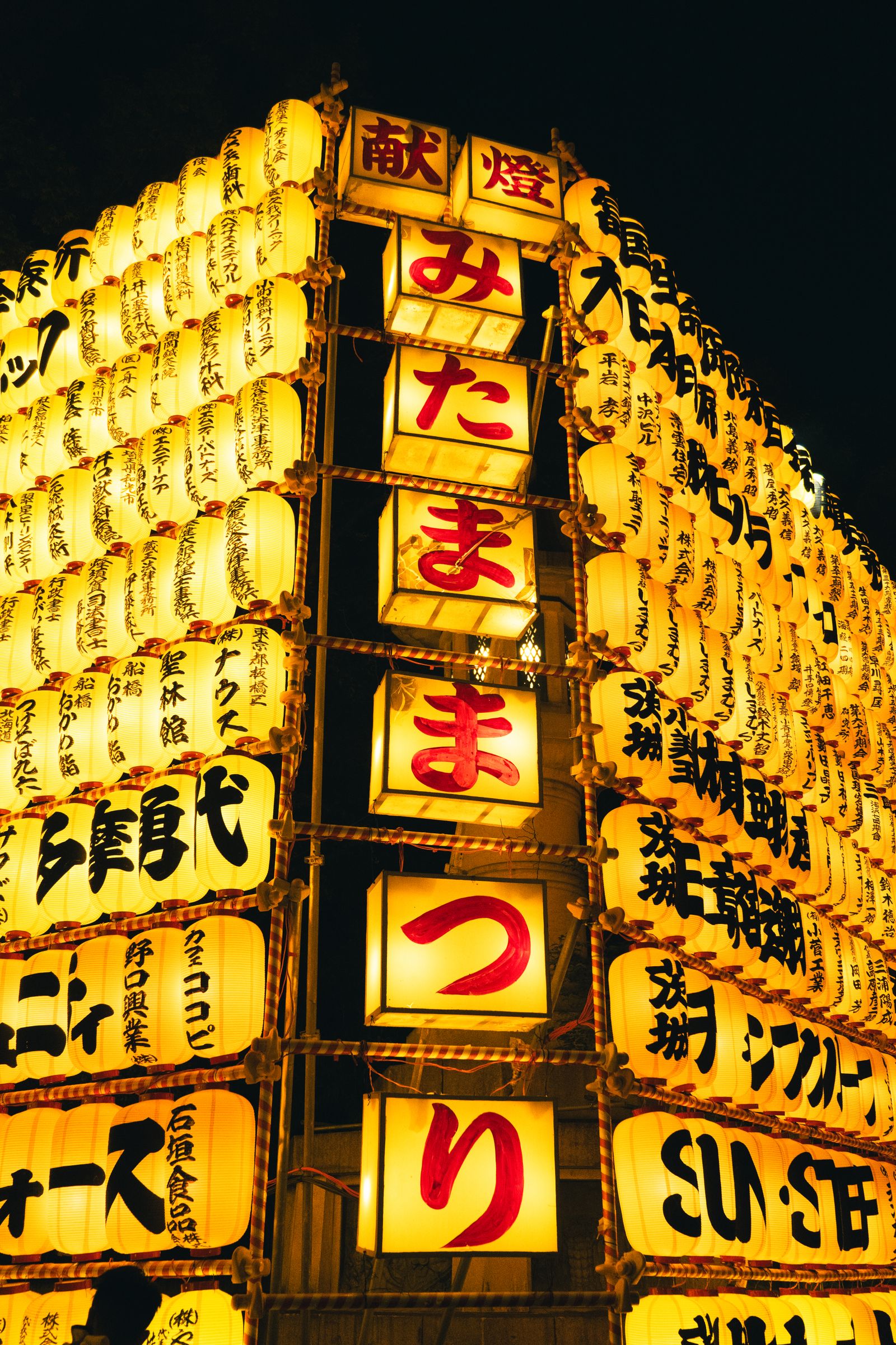 Rows of glowing Mitama festival lanterns at night in Tokyo